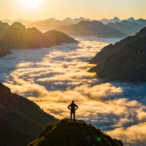 登山者站在山顶俯瞰壮丽群山云海